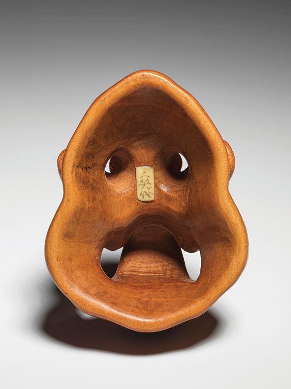 A small okinmono style carving of a mask