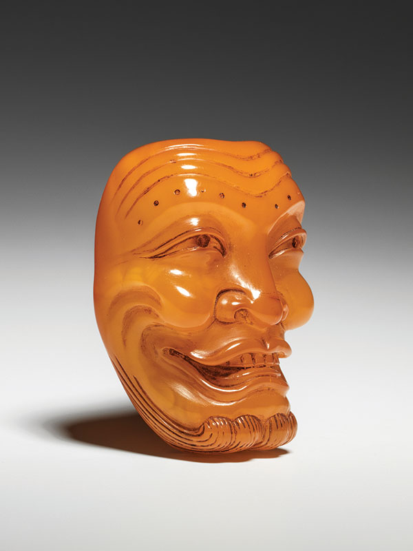 An amber Noh mask netsuke of Okina