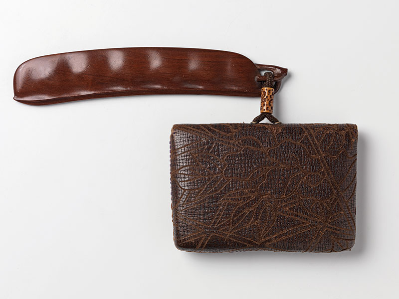 A tooled leather and fabric tobacco pouch